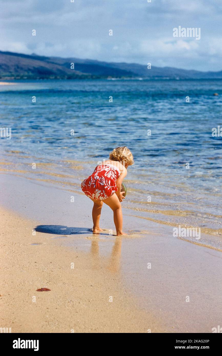 Vista posterior de la niña en la playa, Hawai, EE.UU., Toni Frissell Collection, 1957 Foto de stock