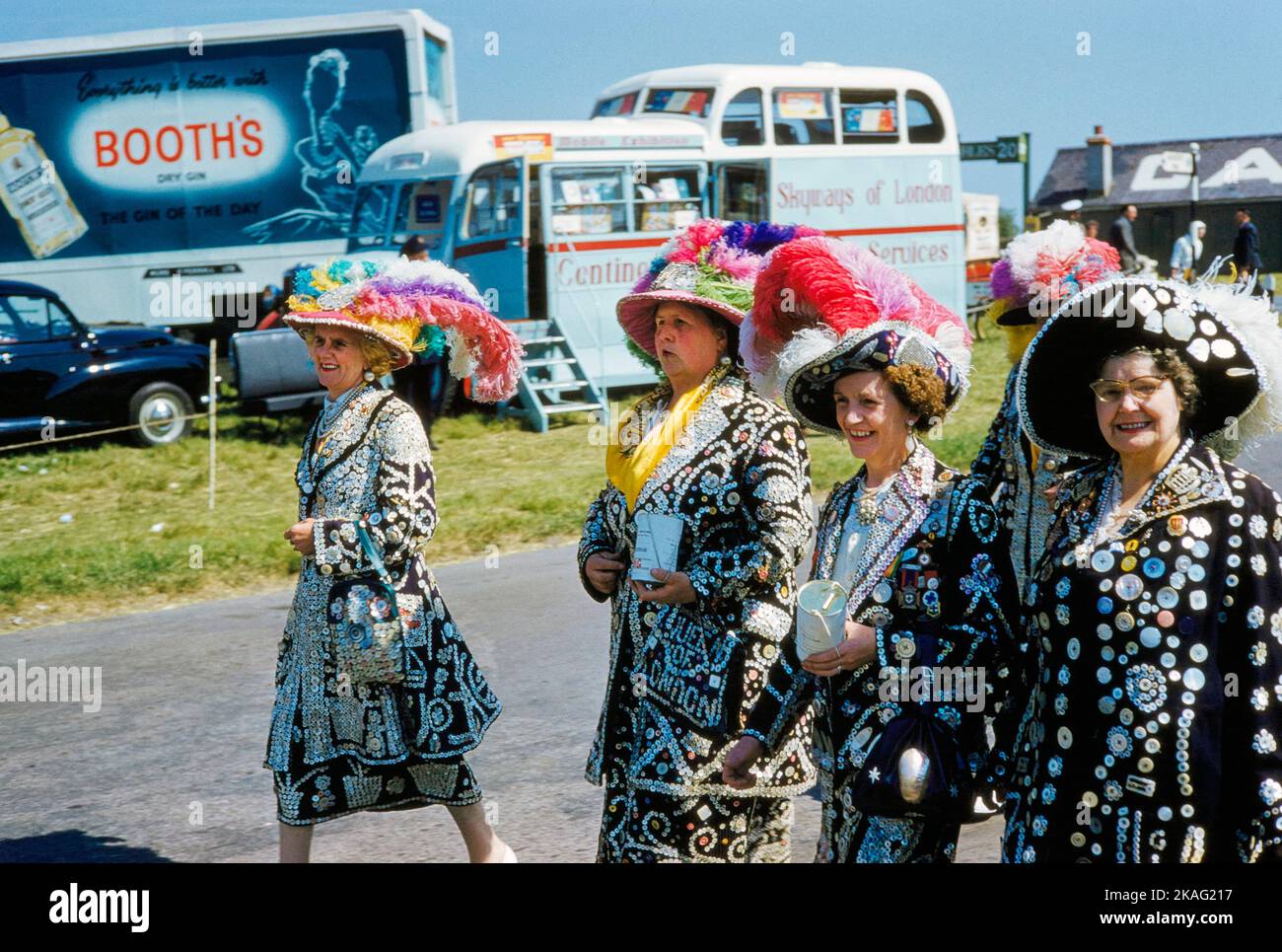 Cuatro mujeres que llevaban chaquetas y faldas con botones de diferentes tamaños cosidos sobre ellas para asistir a English Derby, Epsom Downs Racecourse, Epsom, Surrey, Inglaterra, UK, Toni Frissell Collection, 3 de junio de 1959 Foto de stock
