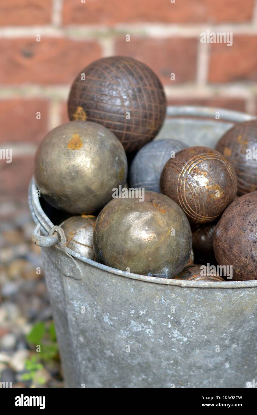 cubo galvanizado de época lleno de bolas de petanca francesa oxidadas Foto de stock