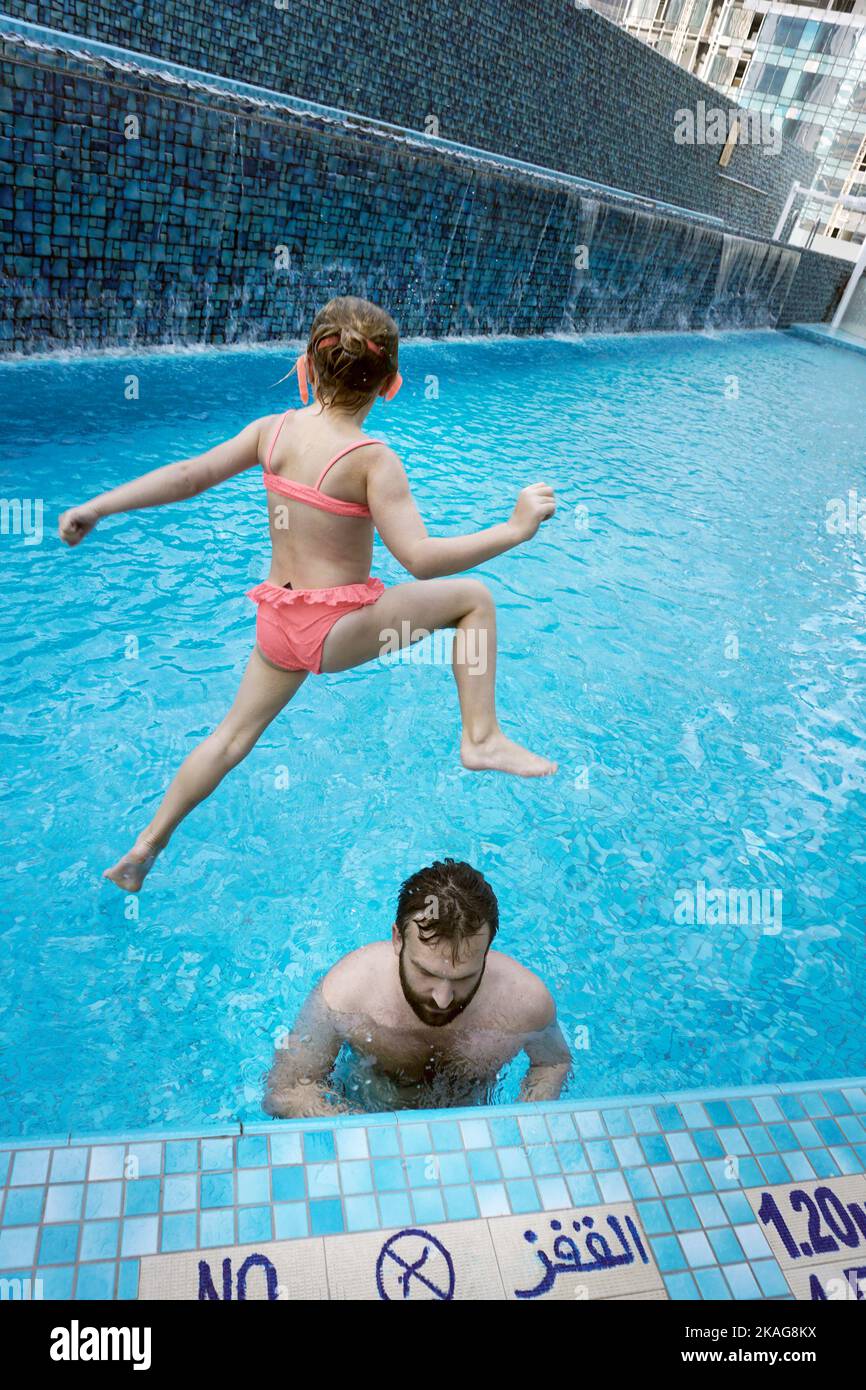 chica joven saltando a la piscina del hotel doha qatar Foto de stock