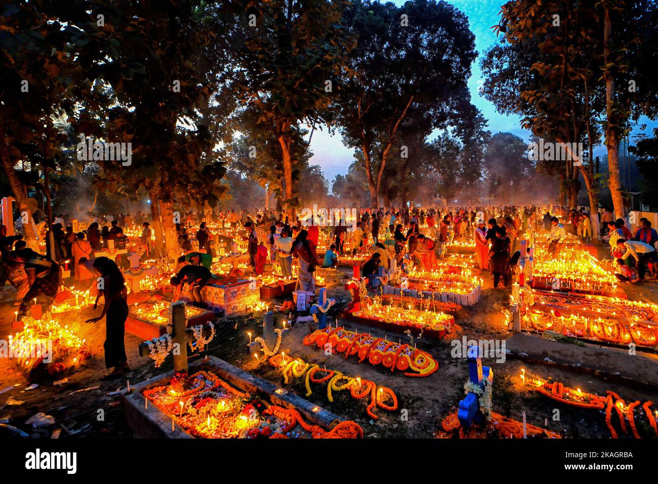 Devotos cristianos ofrecen oraciones junto a las tumbas de sus familiares  fallecidos durante el Día de Todas las Almas en un cementerio. Devotos  cristianos se reúnen en las tumbas de sus seres