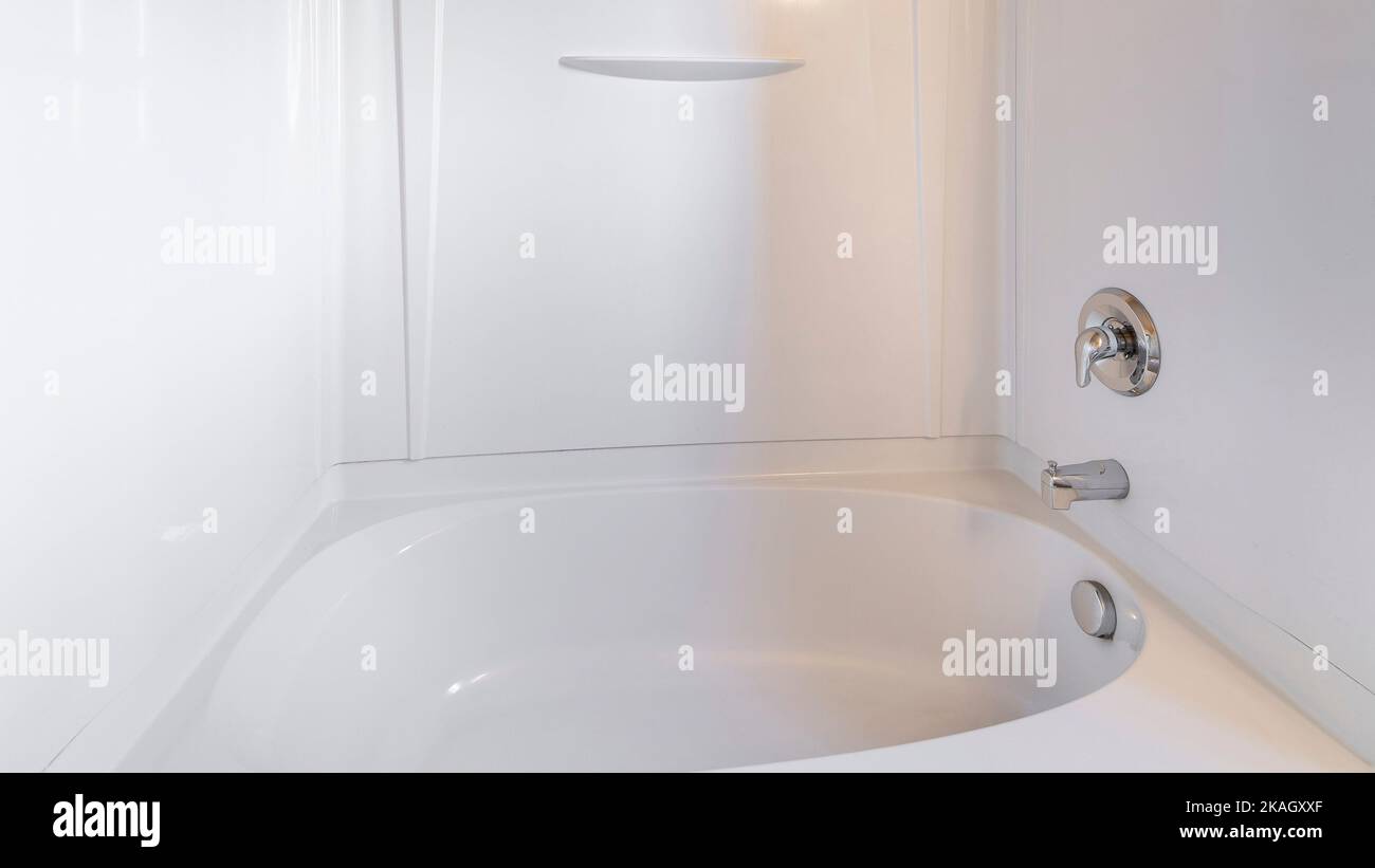Kit combinado de bañera-ducha Panorama Alcove con cabezal de ducha y grifo  montado en la pared. El interior del cuarto de baño tiene una bañera de  pared acrílica que rodea el beige