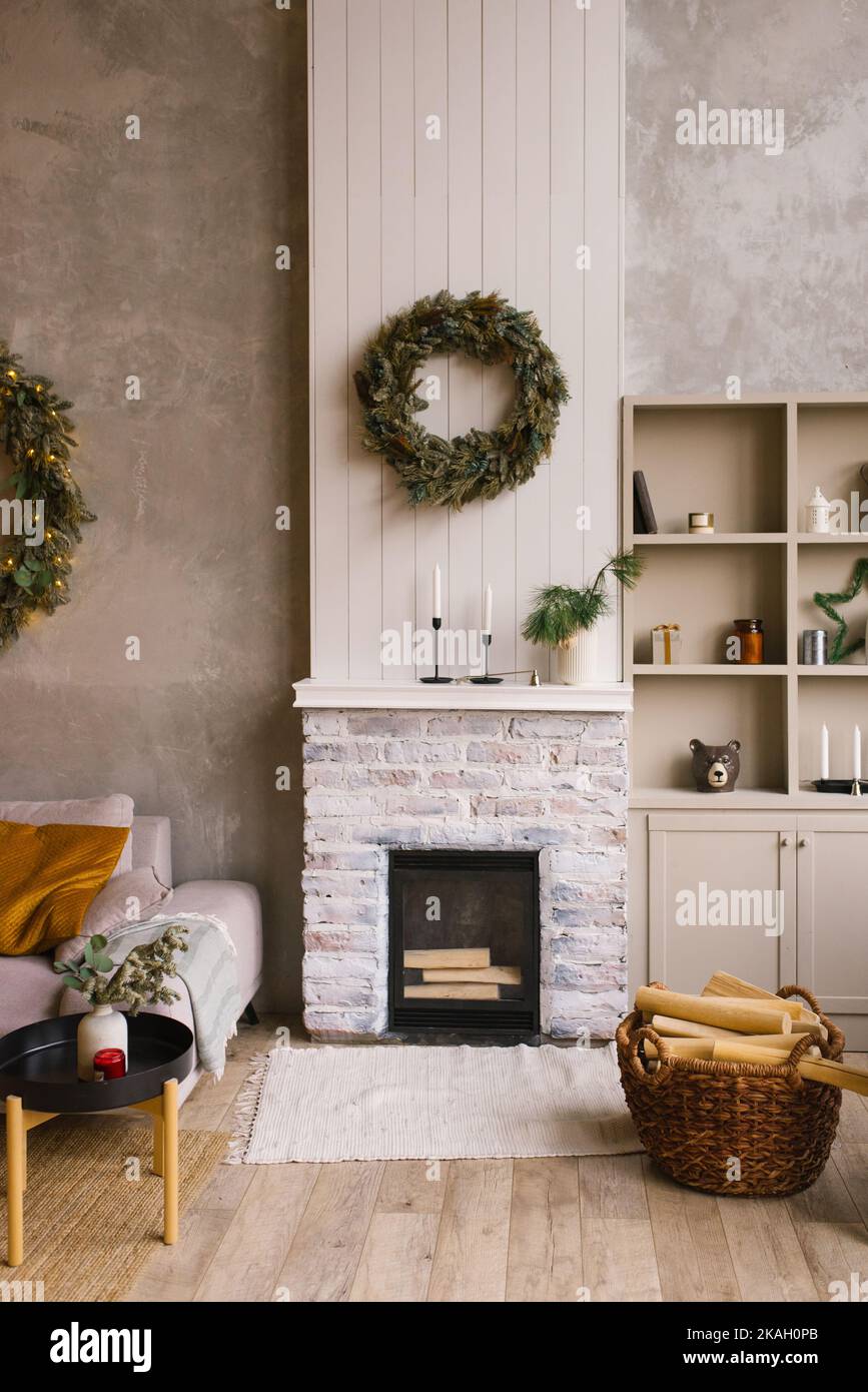 Interior de una casa de campo con chimenea, corona de Navidad, silla de mimbre y decoración para el año nuevo Foto de stock