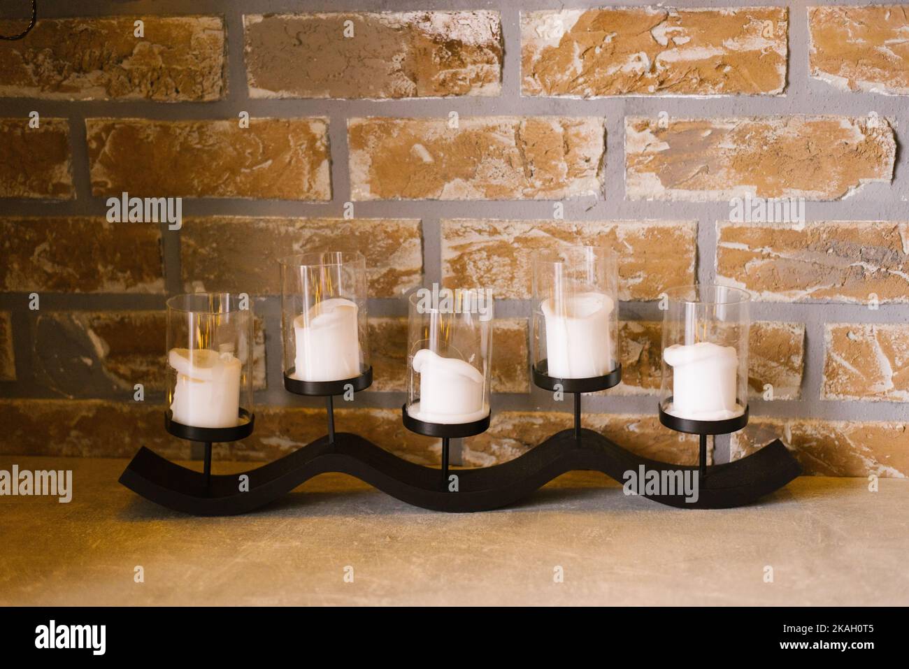 Candelabro moderno con velas blancas en la decoración de un hogar acogedor Foto de stock