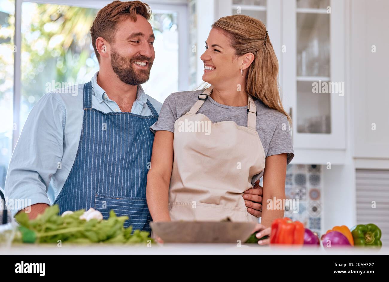 Apuesto hombre sonriente delantal en la cocción de los alimentos en la  cocina Fotografía de stock - Alamy