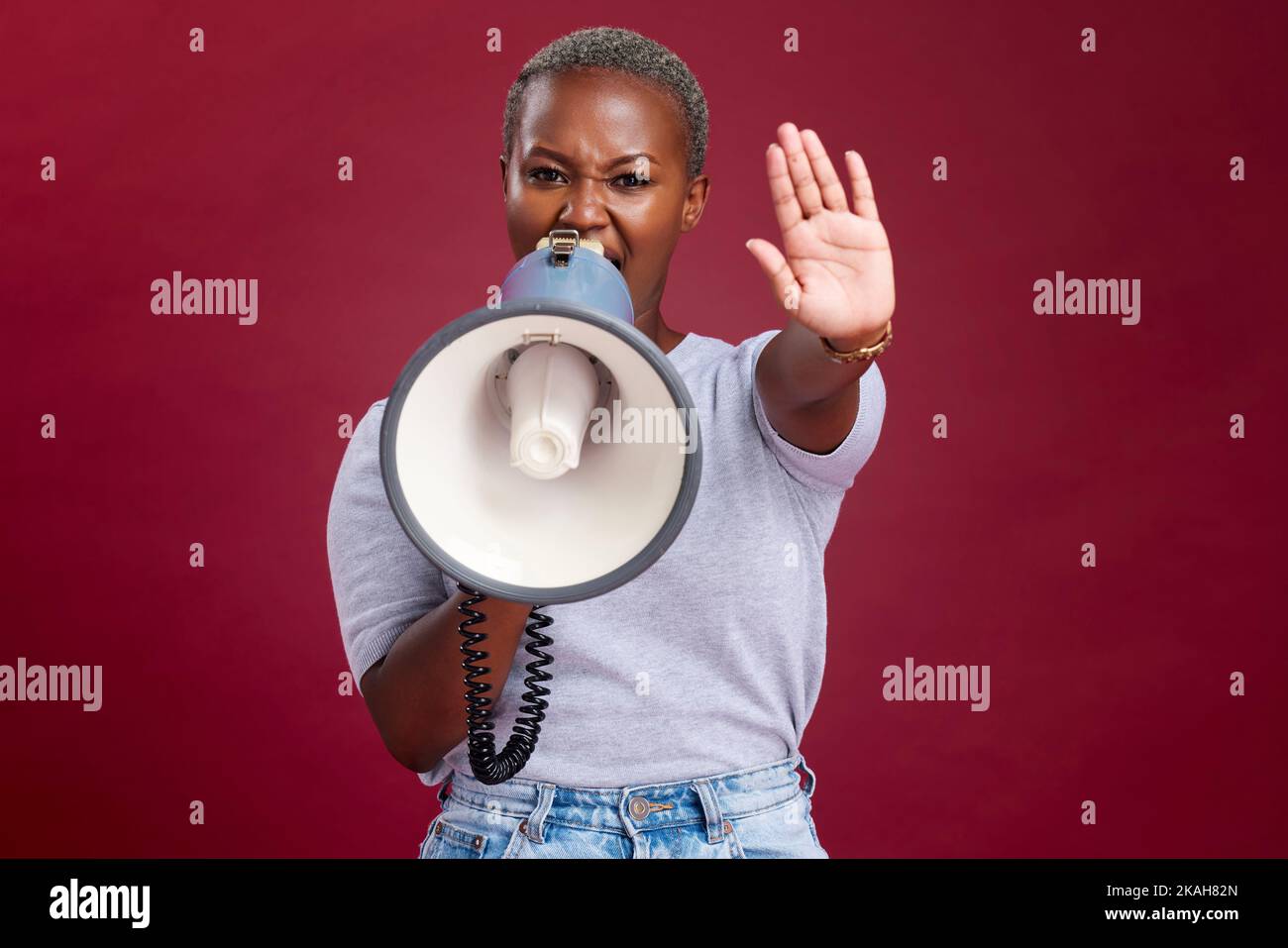 Mujer negra, protesta y gritando con megáfono para la voz, huelga o parada contra un fondo de estudio. Retrato de una activista africana con la mano Foto de stock