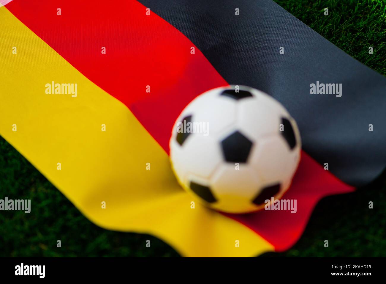 Selección nacional de fútbol de Alemania. Bandera nacional en hierba verde y balón de fútbol. Fondo de pantalla de fútbol para el Campeonato y Torneo en 2022. Internacional interno Foto de stock