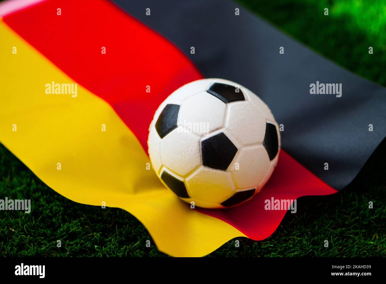 Selección nacional de fútbol de Alemania. Bandera nacional en hierba verde y balón de fútbol. Fondo de pantalla de fútbol para el Campeonato y Torneo en 2022. Internacional interno Foto de stock