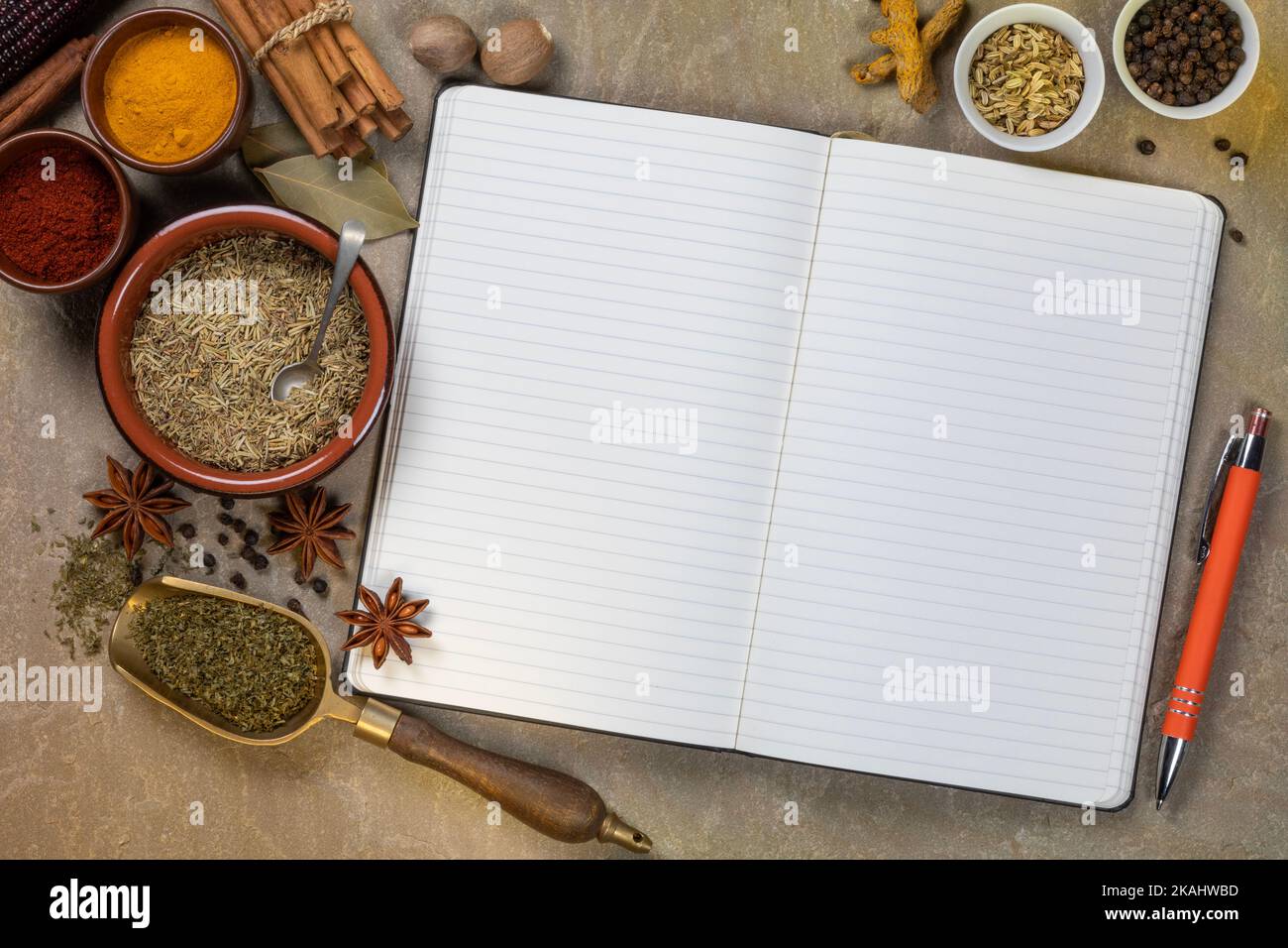 Especias para cocinar utilizadas para agregar sabor y condimentos con un libro de recetas abierto con páginas en blanco - espacio para texto. Foto de stock