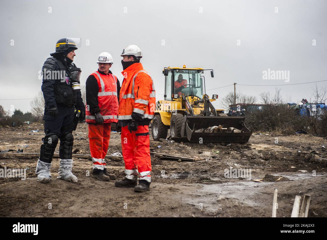 Un trabajador discute con la policía durante la destrucción de la parte sur  de la selva. Una retroexcavadora recoge chozas desmanteladas. En Calais,  Francia, el 1 de marzo de 2016. Según se