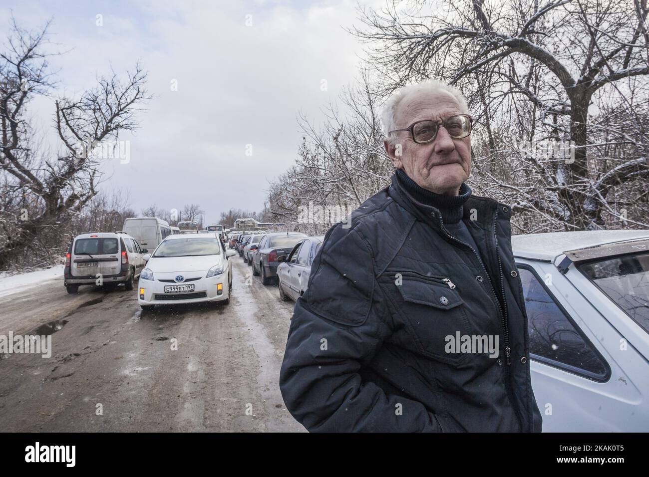 El hombre espera largas colas de coches en invierno para cruzar los puestos de control entre la República de Donetsk PeopleÂ y el ejército ucraniano en Gorlovka, Ucrania, el 15 de diciembre de 2016. (Foto de Celestino Arce/NurPhoto) *** Por favor use el crédito del campo de crédito *** Foto de stock