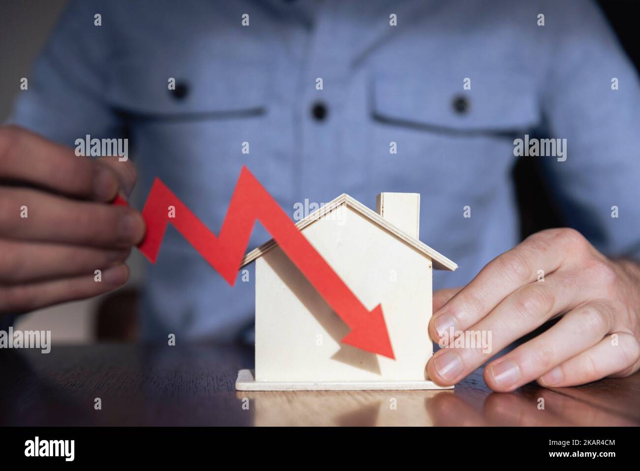 Aumento de la tasa hipotecaria. Modelo de vivienda con una flecha de inflación roja en aumento Foto de stock