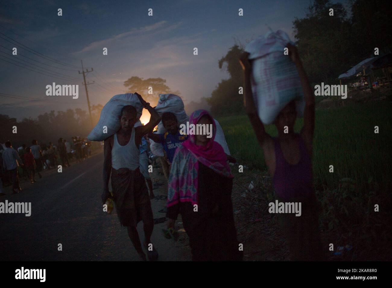 Los refugiados rohingya están regresando al campamento de refugiados de Balukhali después de recoger ayuda. Chittagong, Bangladesh. 15 de septiembre de 2017. Bangladesh utilizará tropas para entregar ayuda extranjera a la ciudad fronteriza que ha sido abrumada por los refugiados musulmanes rohingya de Myanmar, anunciaron las autoridades a finales de septiembre de 14. La medida es consecuencia de las críticas de las condiciones caóticas en las que se han entregado suministros de socorro en los enormes campamentos situados alrededor de Cox's Bazar, a los que han llegado unos 389.000 rohingya del estado de Rakhine en Myanmar desde agosto de 25. (Foto de Turjoy Chowdhury/NurPhoto) Foto de stock