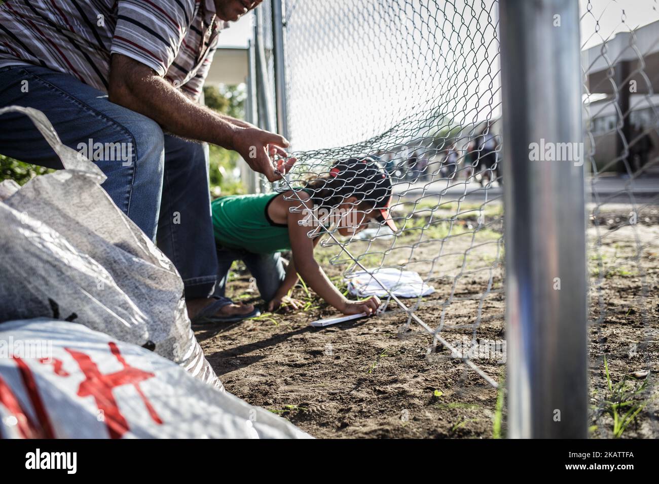 (9/14/2015) Serbia, Horgos. Los migrantes cruzan cerca cableada poco después de cerrar la frontera húngara. Hungría ha sido un importante país de tránsito para los migrantes, muchos de los cuales apuntan a continuar hacia Austria y Alemania. En 2015, Hungría construyó una barrera fronteriza en su frontera con Serbia y Croacia. La valla se construyó durante la crisis de los inmigrantes europeos con el objetivo de garantizar la seguridad fronteriza evitando que los refugiados y los inmigrantes entren ilegalmente, y permitiendo la opción de entrar a través de los puestos de control oficiales y solicitar asilo en Hungría, de conformidad con la legislación internacional y europea. El número Foto de stock