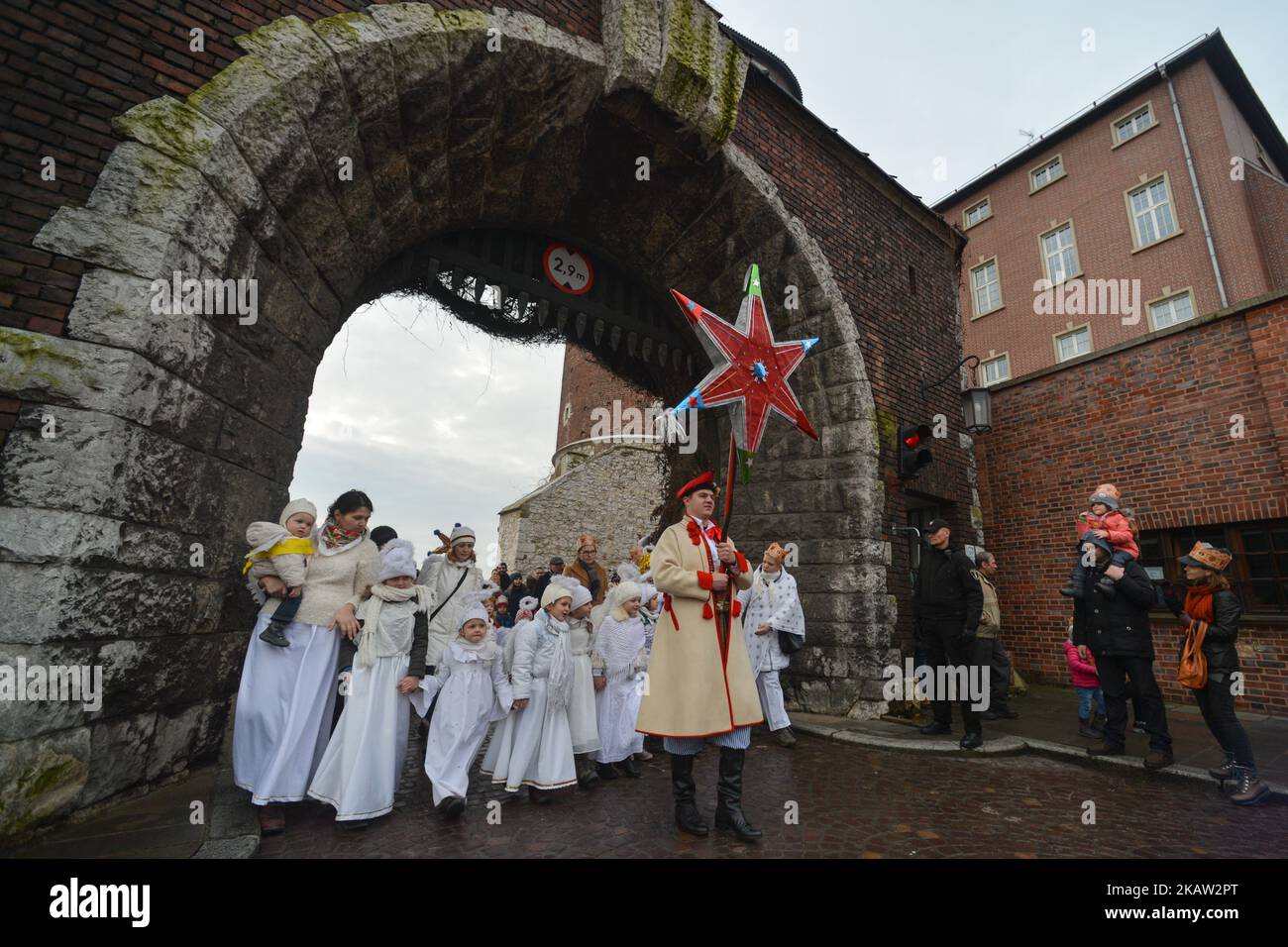 Jóvenes artistas vestidos de ángeles siguen a un hombre que lleva la