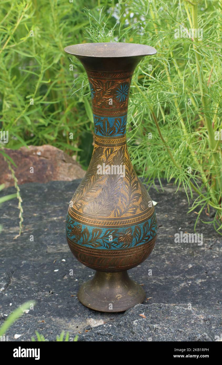 Antiguo jarrón de cobre indio en la piedra Foto de stock