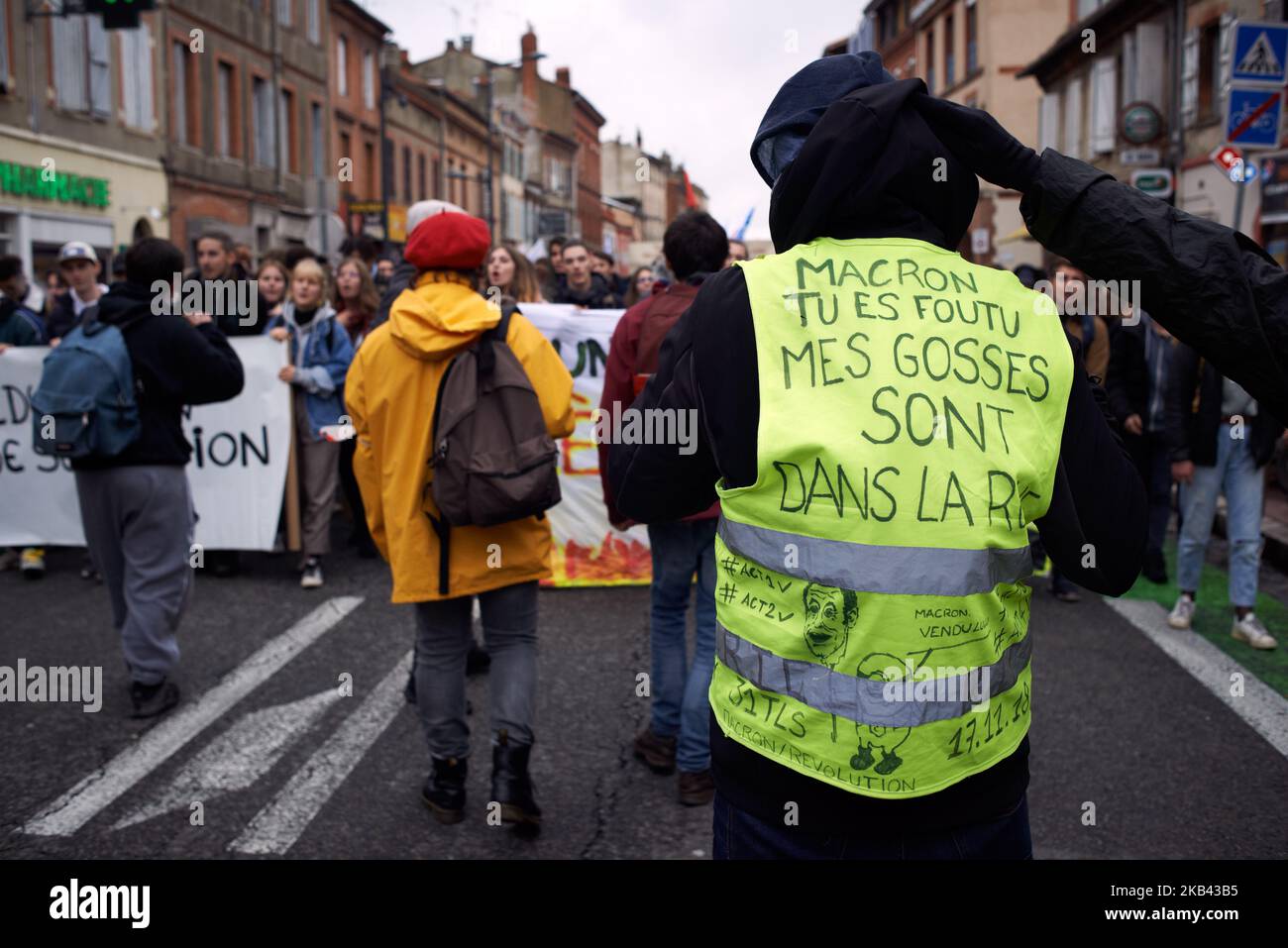 Un chaleco amarillo ha escrito en su espalda 'Macron, estás fuera, mis  hijos están en las calles'. En solidaridad con los Chalecos Amarillos,  estudiantes de secundaria, profesores y sindicalistas de la CGT,