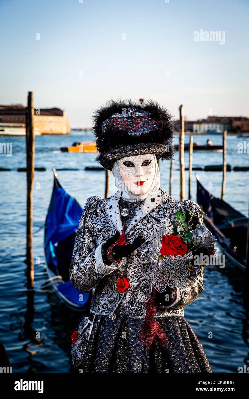 Las personas que visten disfraces de Carnaval posan cerca de los San Marcos  el 20 de febrero de 2020 en Venecia, Italia. El tema de la 2020 edición del  Carnaval de Venecia