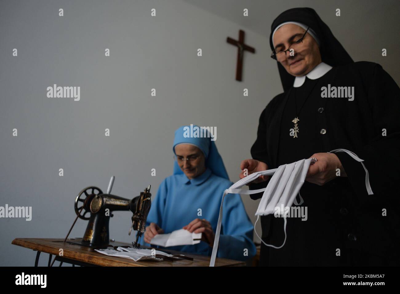 Monjas de la orden religiosa de las Hermanas del Canon del Espíritu Santo cosiendo máscaras protectoras dentro de su convento en Cracovia. Las hermanas se solidarizan con toda persona que necesita su presencia y oraciones, y responden a las necesidades de las crisis del coronavirus ayudando a los sin hogar. Cada día las monjas abren la ventana de su convento llamada 'Gwidon's Window' (nombre del fundador de la orden) en el centro de Cracovia, y a través de ella sirven comidas a los pobres. Apreciando el trabajo sacrificial de todos los trabajadores médicos y voluntarios, ellos quieren ayudarles haciendo máscaras protectoras. Activado Foto de stock