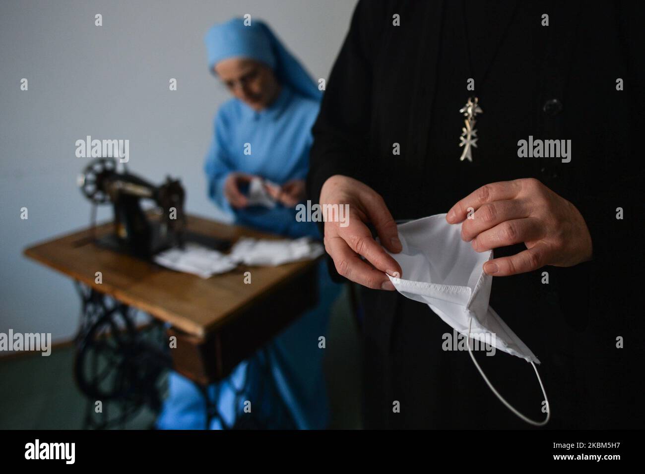 Monjas de la orden religiosa de las Hermanas del Canon del Espíritu Santo cosiendo máscaras protectoras dentro de su convento en Cracovia. Las hermanas se solidarizan con toda persona que necesita su presencia y oraciones, y responden a las necesidades de las crisis del coronavirus ayudando a los sin hogar. Cada día las monjas abren la ventana de su convento llamada 'Gwidon's Window' (nombre del fundador de la orden) en el centro de Cracovia, y a través de ella sirven comidas a los pobres. Apreciando el trabajo sacrificial de todos los trabajadores médicos y voluntarios, ellos quieren ayudarles haciendo máscaras protectoras. Activado Foto de stock