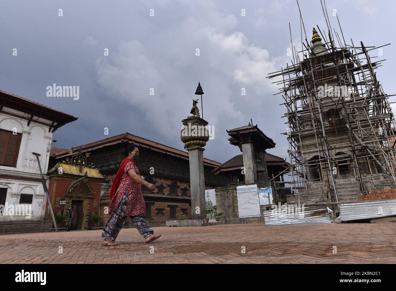 Una mujer camina hacia su casa después de comprar productos básicos diarios durante el cierre total de la nación como preocupación por la propagación del virus Corona (COVID-19) en Bhaktapur, Nepal el miércoles, 29 de abril de 2020. (Foto de Narayan Maharjan/NurPhoto) Foto de stock
