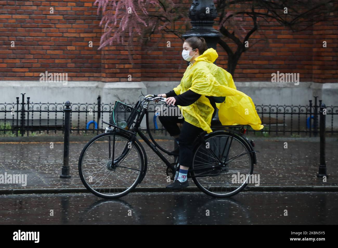 equivocado Subproducto anfitrión Una mujer con chubasquero montando en bicicleta lleva una máscara  protectora debido a la propagación del coronavirus durante la lluvia  primaveral en Cracovia, Polonia, el 1at de mayo de 2020. La regla