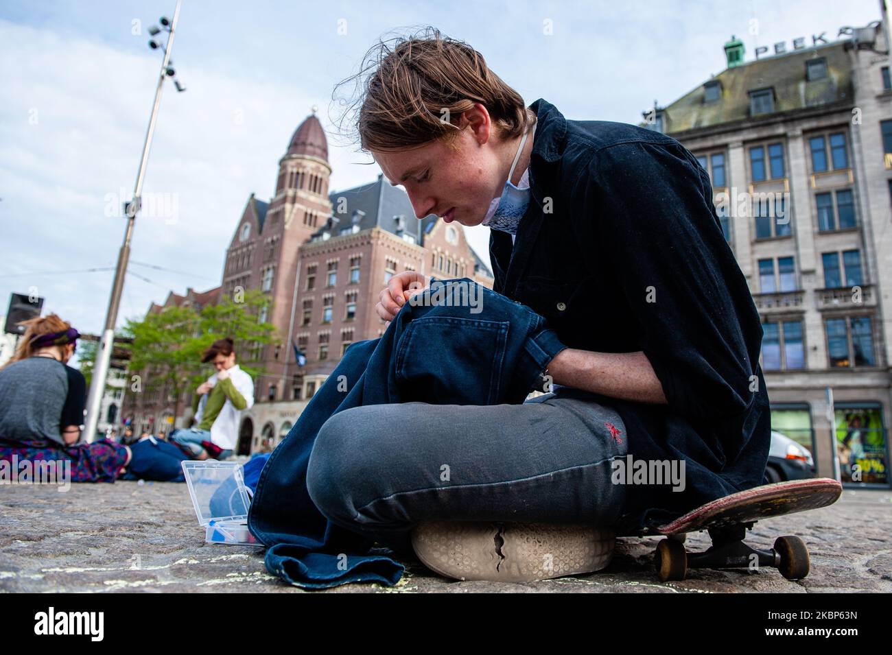 Un activista de XR está cosiendo ropa usada, durante una acción de XR contra la industria de la moda rápida en Ámsterdam, el 22nd de mayo de 2020. (Foto de Romy Arroyo Fernandez/NurPhoto) Foto de stock