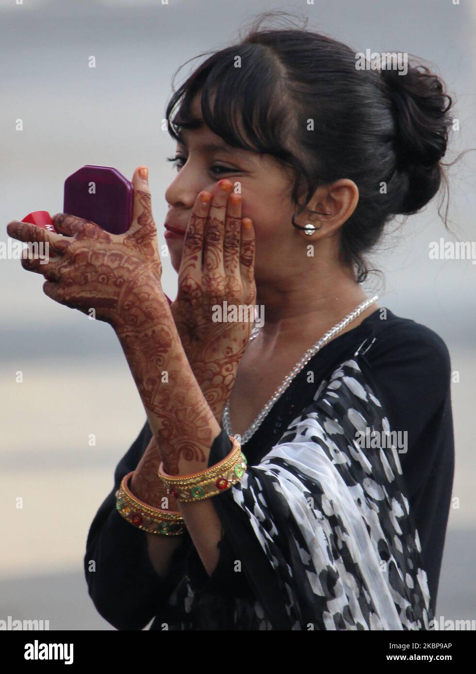 Una niña musulmana aplica maquillaje junto a una carretera durante Eid al-Fitr en Mumbai, India, el 25 de mayo de 2020. Eid marca el del mes santo de que