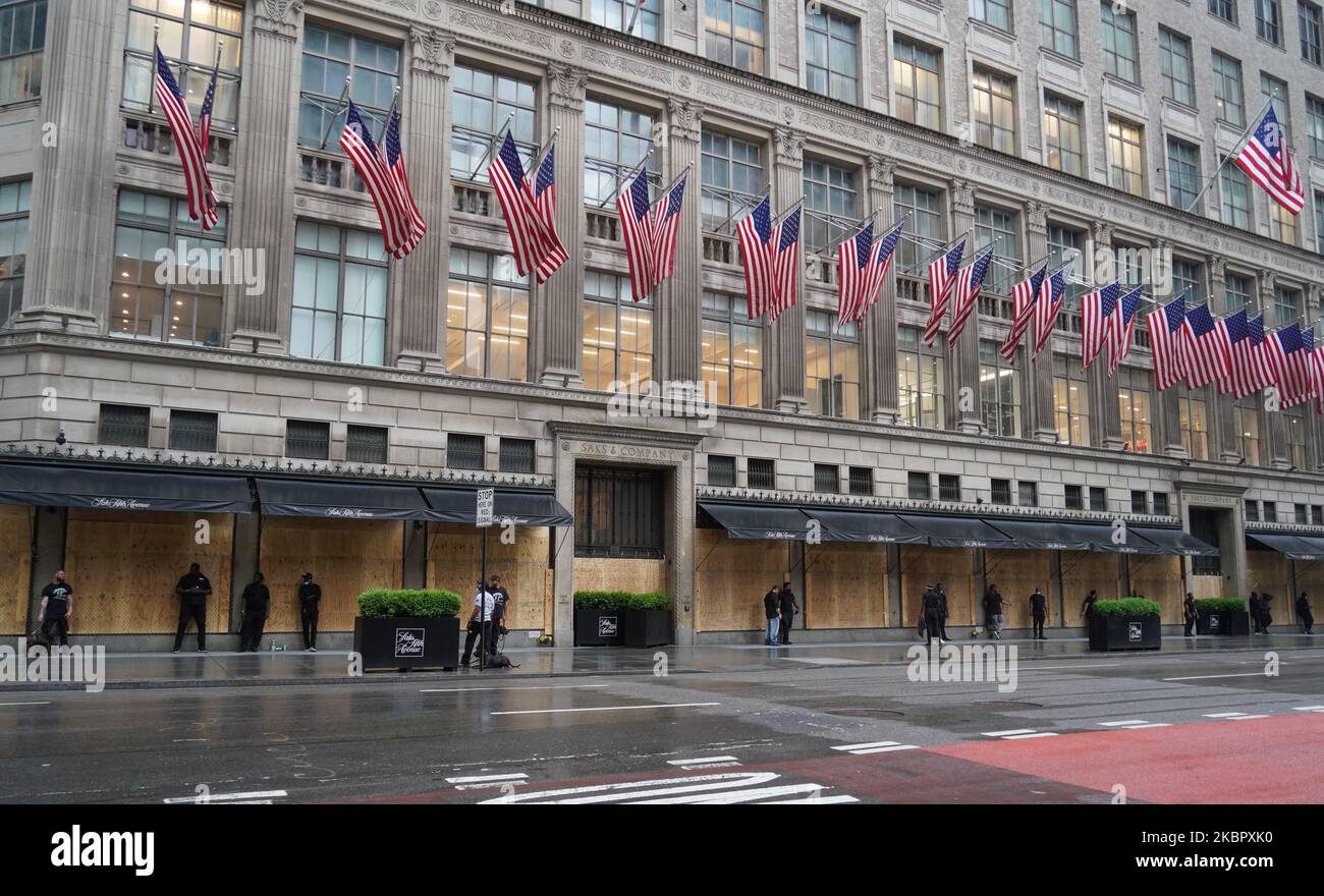 El afamado Saks Fifth Avenue en la ciudad de Nueva York se preparó contra el saqueo el 5 de junio por guardias de seguridad con perros y una valla de cadena sobre las ventanas abordadas durante las protestas de George Floyd que se extendieron por grandes ciudades de Estados Unidos. (Foto de Selcuk Acar/NurPhoto) Foto de stock