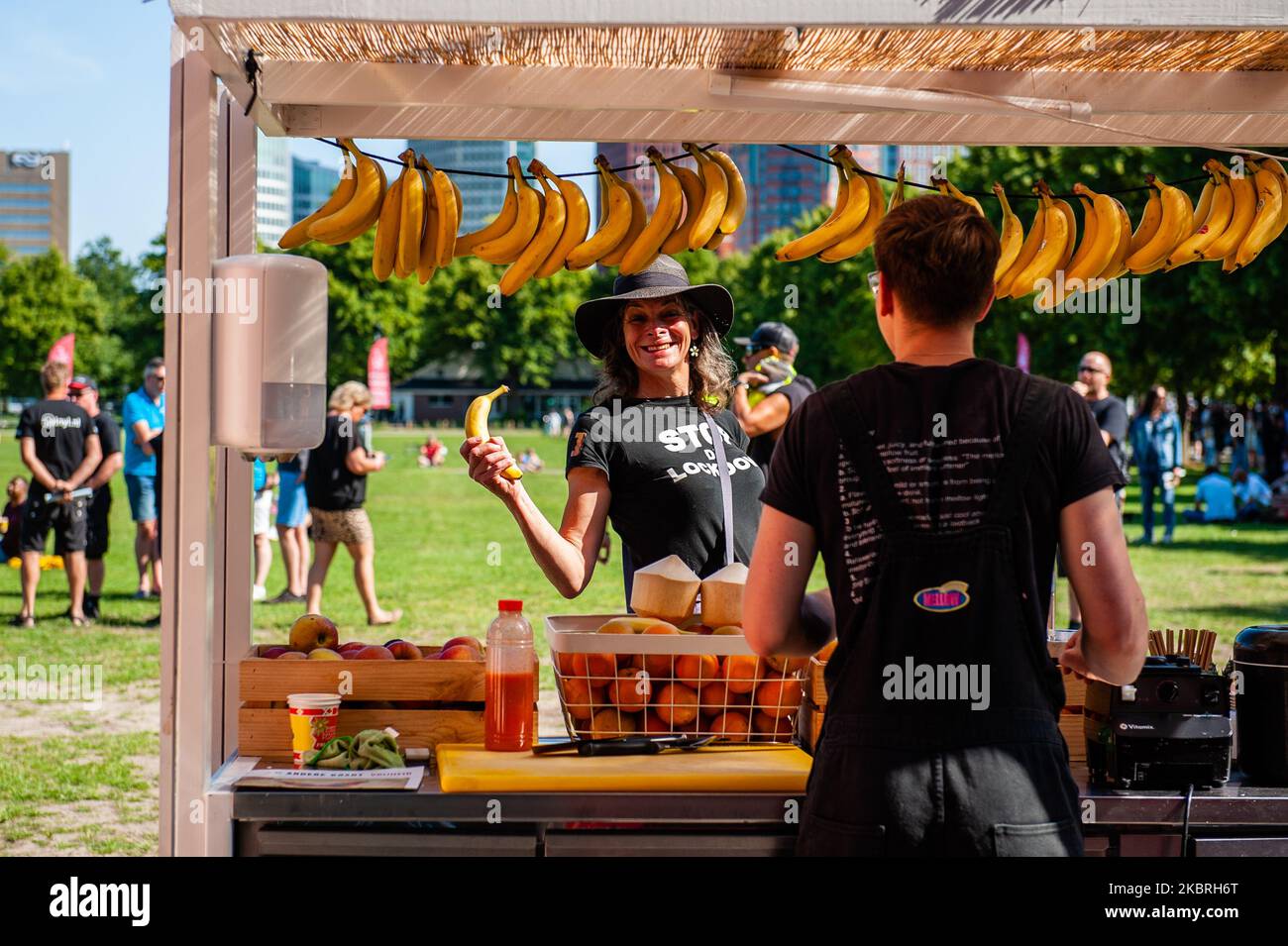 Una mujer que lleva una camiseta anti-bloqueo está comprando un plátano de uno de los camiones de comida, durante la protesta de los trabajadores de la industria hotelera, en La Haya, Países Bajos, el 23 de junio de 2020. (Foto de Romy Arroyo Fernandez/NurPhoto) Foto de stock