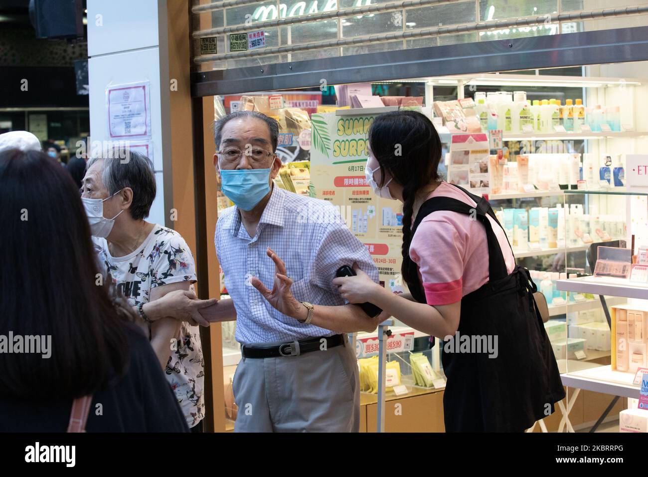 Una pareja de ancianos huyen de una tienda mientras la policía declara que todos los habitantes de la zona forman parte de una asamblea ilegal en Mong Kok, Hong Kong, China, el 28 de junio de 2020. Mong Kok es una de las partes más densamente pobladas del mundo. (Foto de Simon Jankowski/NurPhoto) Foto de stock