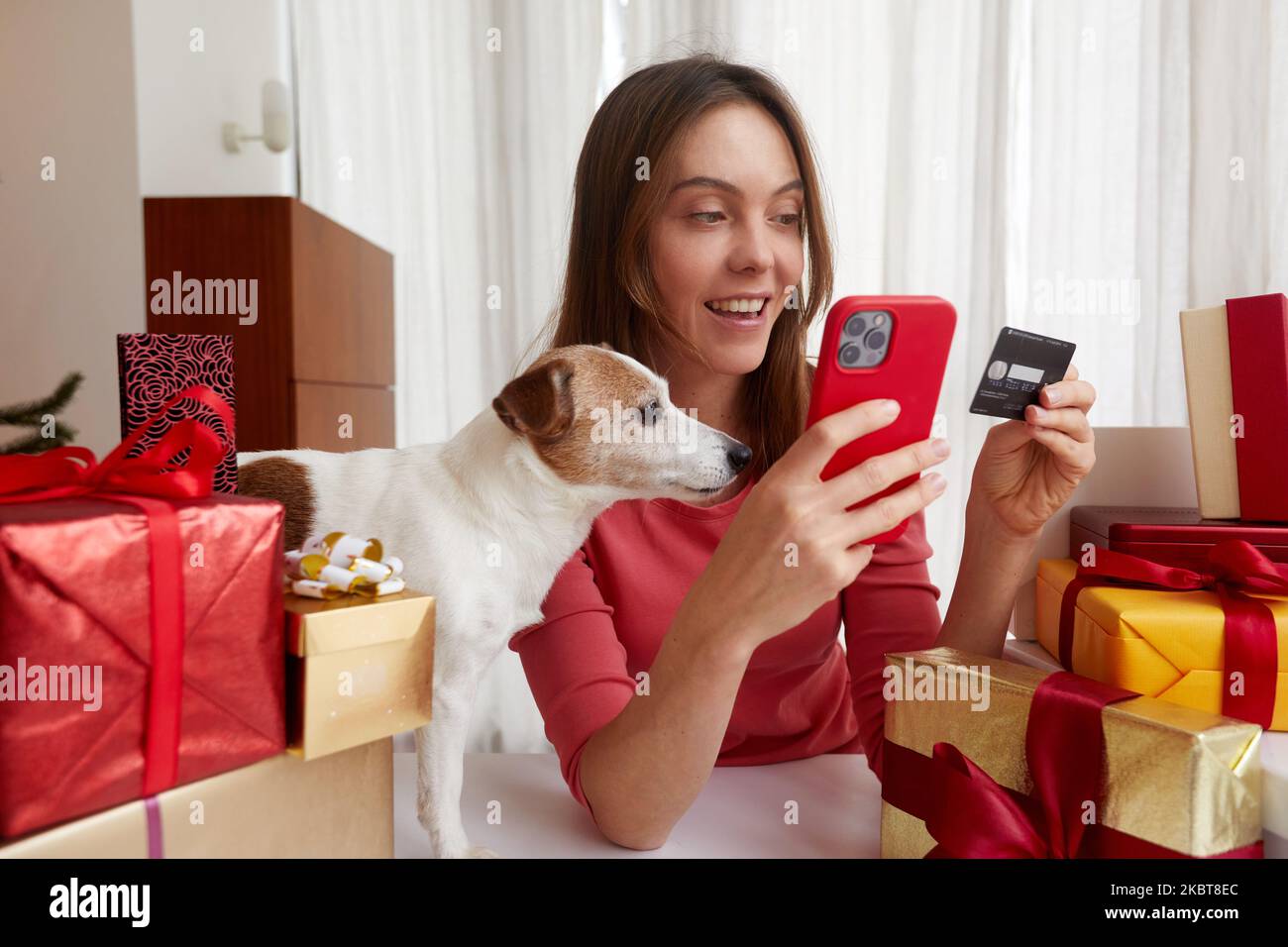 Señora que compra en línea con tarjeta de crédito y smartphone casa mascota Foto de stock