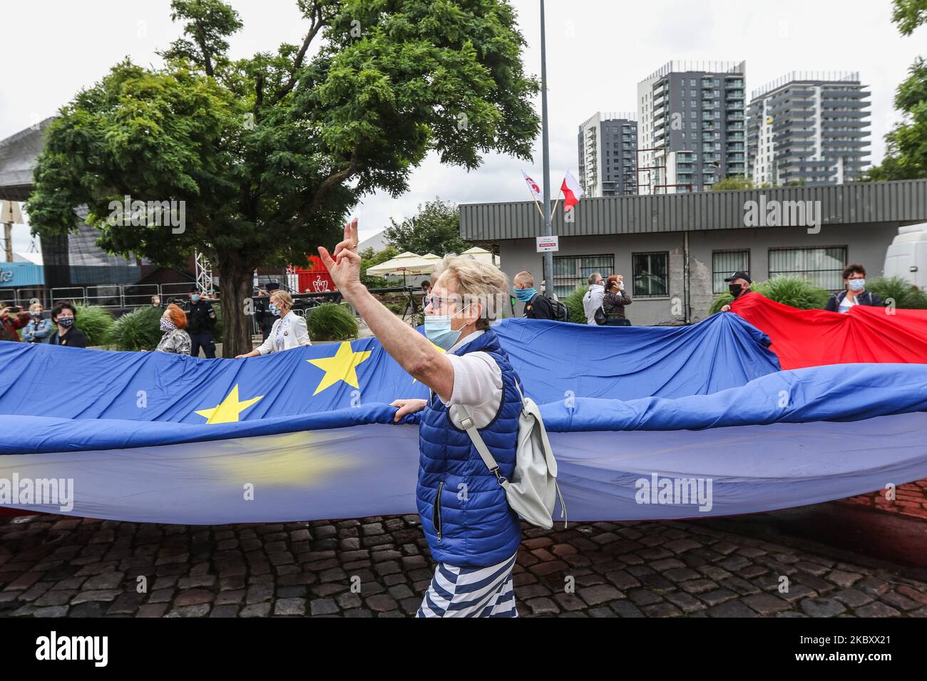 Una mujer que muestra un signo de victoria con banderas gigantes polacas y de la UE se ve en Gdansk, Polonia, el 31 de agosto de 2020, Lech Walesa y otros líderes y miembros de los partidos de oposición celebran el aniversario de los Acuerdos de Agosto en Gdansk en la Plaza de Solidaridad de Gdansk (Foto de Michal Fludra/NurPhoto) Foto de stock