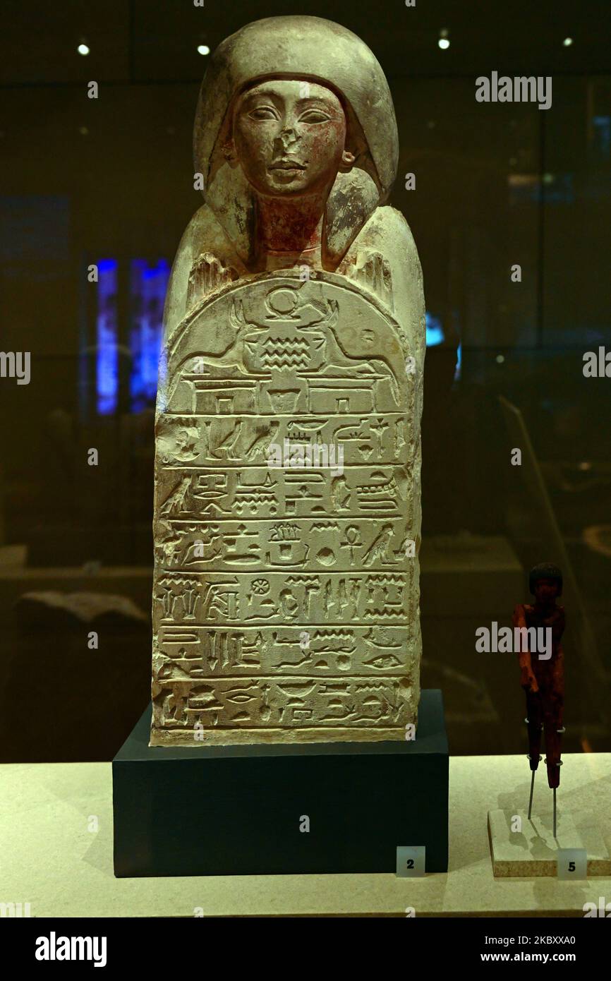Estatua de basalto egipcio de una figura masculina que llevaba una peluca de bolsa de finales del período (525-332 aC) y un fragmento de una escultura de piedra caliza de Maanakhtef de Foto de stock