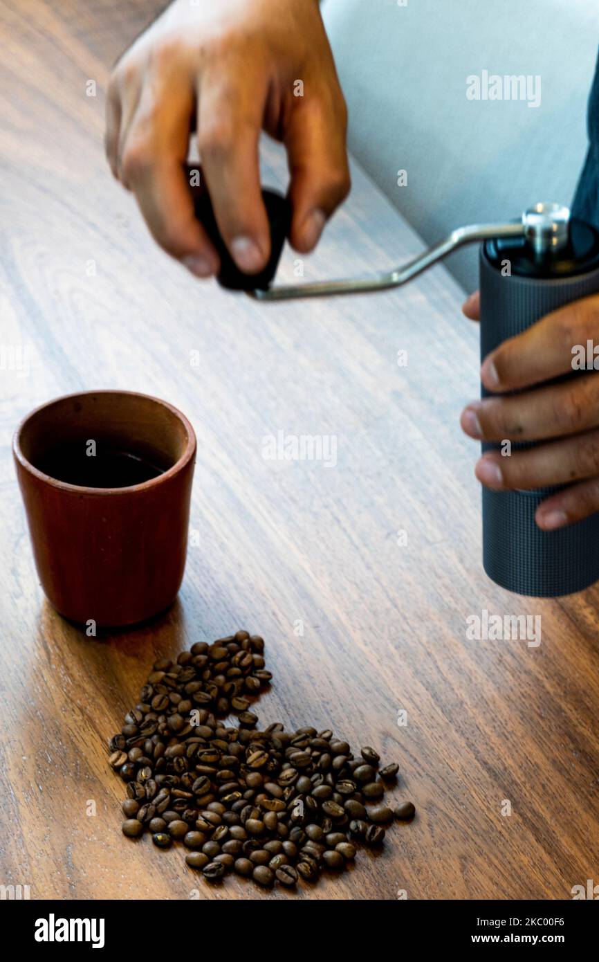 Los granos de café sobre una pila de café molido son primeros planos. Foto de stock