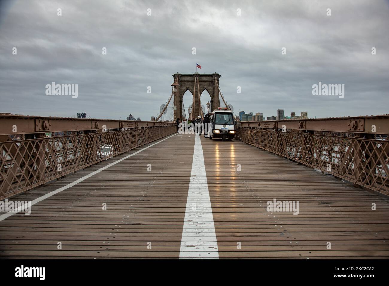 La policía y la gente en el puente de Brooklyn en la ciudad de Nueva York en los Estados Unidos como visto durante un día nublado con turistas y locales en él. El famoso puente, un punto de referencia para Nueva York y los Estados Unidos de América es un puente suspendido de cable híbrido que abarca el río East entre los distritos de Manhattan y Brooklyn. El histórico puente de Nueva York fue construido entre 1869 y 1883. Nueva York, EE.UU. El 13 de febrero de 2020 (Foto de Nicolas Economou/NurPhoto) Foto de stock