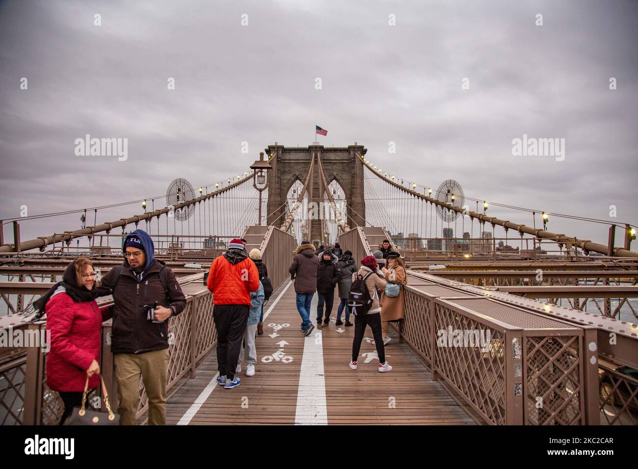 El puente de Brooklyn en la ciudad de Nueva York en los Estados Unidos, visto durante un día nublado con turistas y lugareños en él. El famoso puente, un punto de referencia para Nueva York y los Estados Unidos de América es un puente suspendido de cable híbrido que abarca el río East entre los distritos de Manhattan y Brooklyn. El histórico puente de Nueva York fue construido entre 1869 y 1883. Nueva York, EE.UU. El 13 de febrero de 2020 (Foto de Nicolas Economou/NurPhoto) Foto de stock