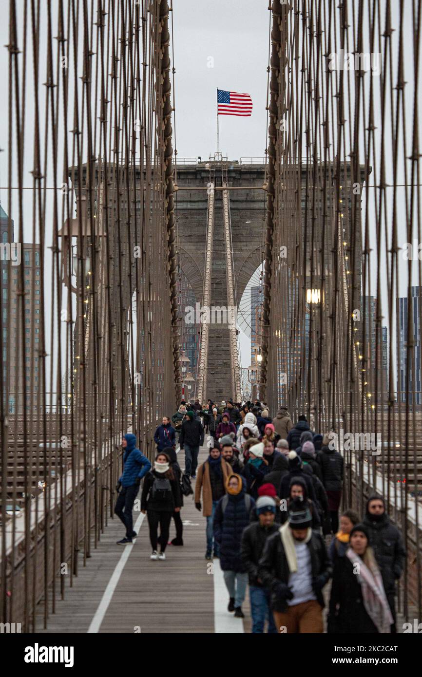 Cientos de personas en el Puente de Brooklyn en la ciudad de Nueva York en los Estados Unidos, visto durante un día nublado con turistas y lugareños en él. El famoso puente, un punto de referencia para Nueva York y los Estados Unidos de América es un puente suspendido de cable híbrido que abarca el río East entre los distritos de Manhattan y Brooklyn. El histórico puente de Nueva York fue construido entre 1869 y 1883. Nueva York, EE.UU. El 13 de febrero de 2020 (Foto de Nicolas Economou/NurPhoto) Foto de stock