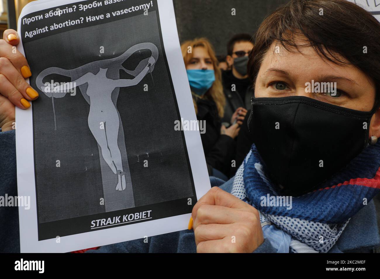 Una mujer sostiene un cartel que dice 'Contra el aborto? Tener una vasectomía' durante la manifestación en Kiev, Ucrania, 26 de octubre de 2020. Partidarios y miembros de movimientos feministas se reúnen frente a la Embajada de Polonia en apoyo de la lucha de las mujeres polacas contra la ley antiaborto. (Foto de Sergii Kharchenko/NurPhoto) Foto de stock