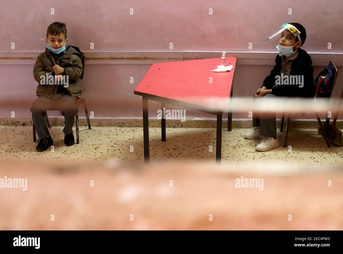 Los escolares palestinos, vestidos con máscaras y protectores para la cara debido a la pandemia del coronavirus COVID-19, se sentaron en un aula en la ciudad de Gaza el 23 de noviembre de 2020. (Foto de Majdi Fathi/NurPhoto) Foto de stock