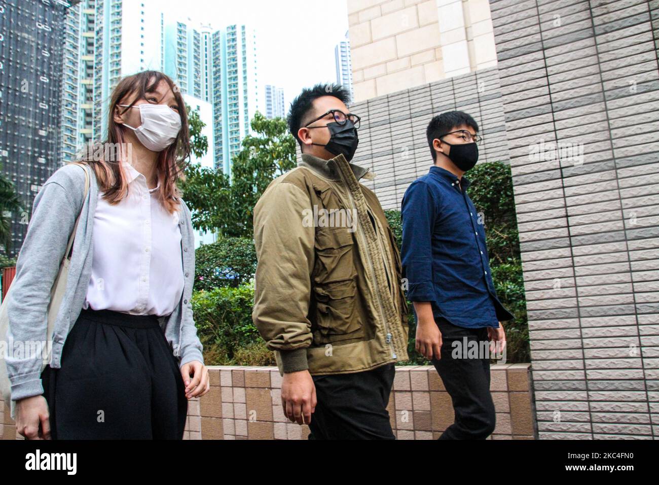 Agnes Chow (izquierda), Ivan Lam (centro) y Joshua Wong (derecha), activistas de Hong Kong, asisten a la corte que enfrenta cargos de reunión ilegal de las protestas de la ciudad en 2019, Kowloon, Hong Kong, 23rd de noviembre de 2020 (Foto de Tommy Walker/NurPhoto) Foto de stock