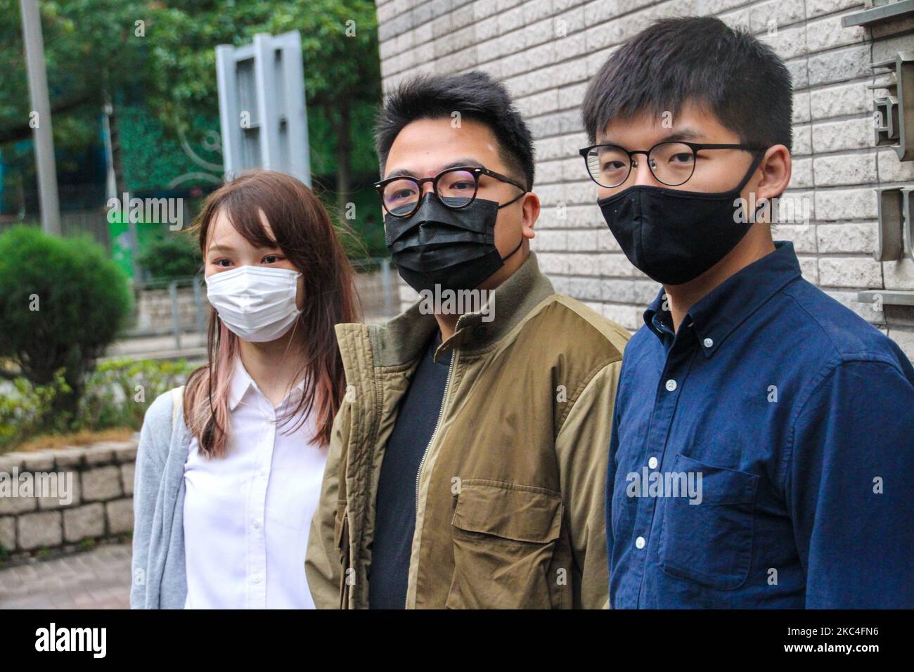 Agnes Chow (izquierda), Ivan Lam (centro) y Joshua Wong (derecha), activistas de Hong Kong, asisten a la corte que enfrenta cargos de reunión ilegal de las protestas de la ciudad en 2019, Kowloon, Hong Kong, 23rd de noviembre de 2020 (Foto de Tommy Walker/NurPhoto) Foto de stock