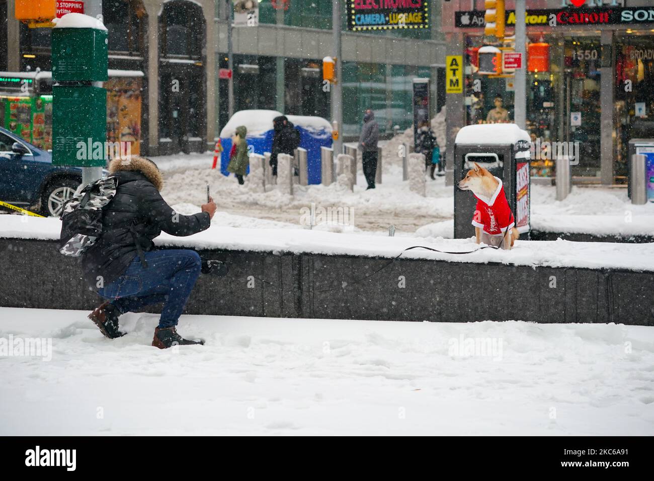 Una visión de una persona tomando una foto de su perro vestido con el traje  de Santa Claus en Times Square el 17 de diciembre de 2020 en Nueva York, la  mañana