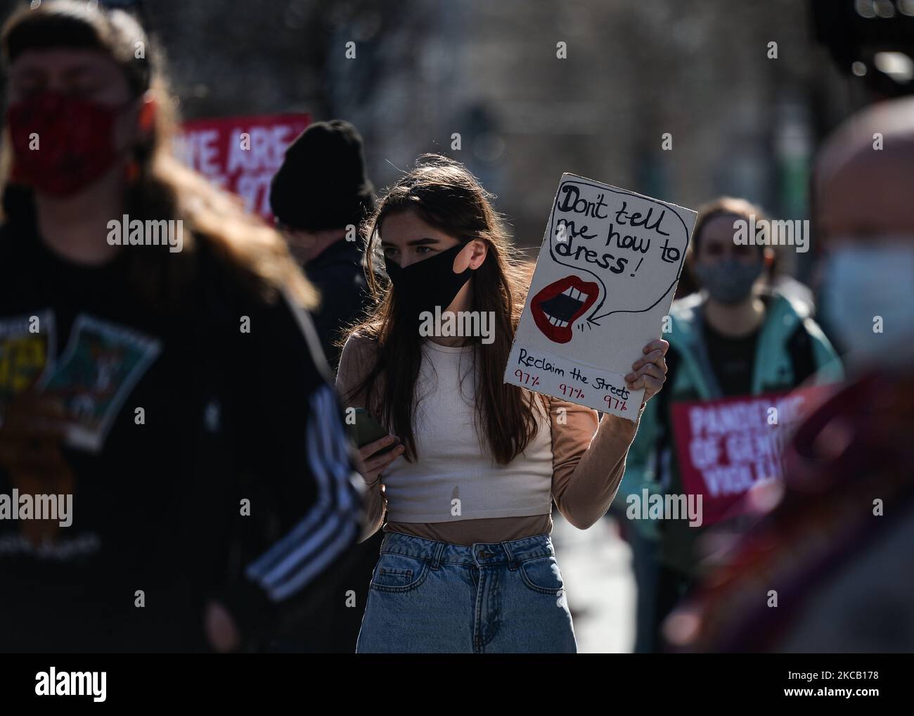 Un activista sostiene un cartel que dice '¡No me digas cómo vestirme!' Durante una protesta de solidaridad con las mujeres en el Reino Unido contra la violencia de género vista en O'Connell Street en Dublín. El trágico asesinato de Sarah Everard, de 33 años de edad, en Londres provocó indignación entre las mujeres de Gran Bretaña, Irlanda y de todo el mundo. Los activistas exigen nuevas medidas para combatir la violencia contra las mujeres. El martes 16 de marzo de 2021, en Dublín, Irlanda. (Foto de Artur Widak/NurPhoto) Foto de stock