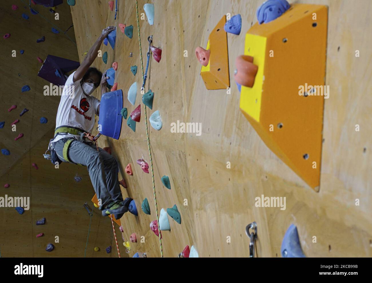 Un escalador sube por la pared artificial durante una sesión de