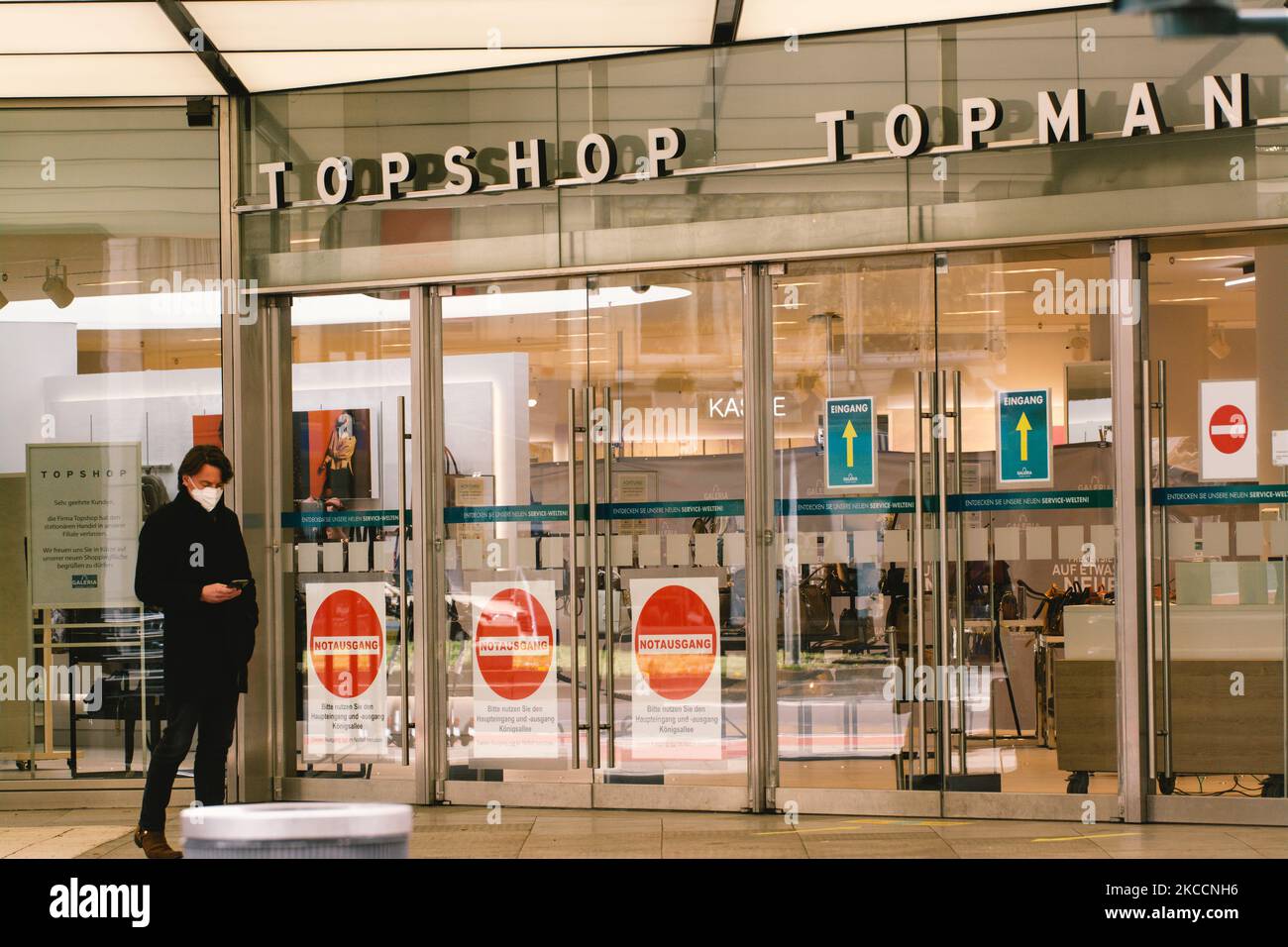 Un hombre es visto en un frente de tienda de Topshop en el centro de la  ciudad de Duesseldorf, Alemania el 13 de abril de 2021 como Duesseldorf  lanza con compras con