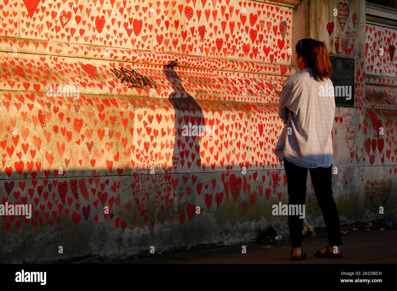 Una mujer observa la Muralla Nacional de Corazones, cada corazón que representa una muerte individual por coronavirus, a la luz del sol de la tarde en Londres, Inglaterra, el 22 de abril de 2021. (Foto de David Cliff/NurPhoto) Foto de stock