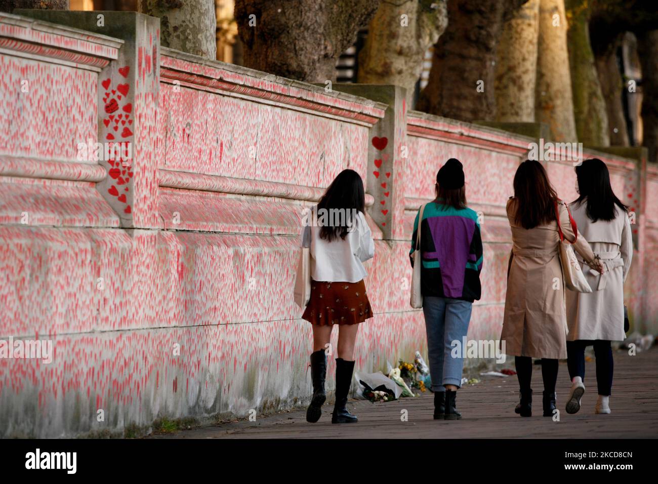Un grupo de mujeres caminan junto al Muro Conmemorativo Nacional de los Corazones de Covid, cada corazón representa una muerte individual por coronavirus, en Londres, Inglaterra, el 22 de abril de 2021. (Foto de David Cliff/NurPhoto) Foto de stock