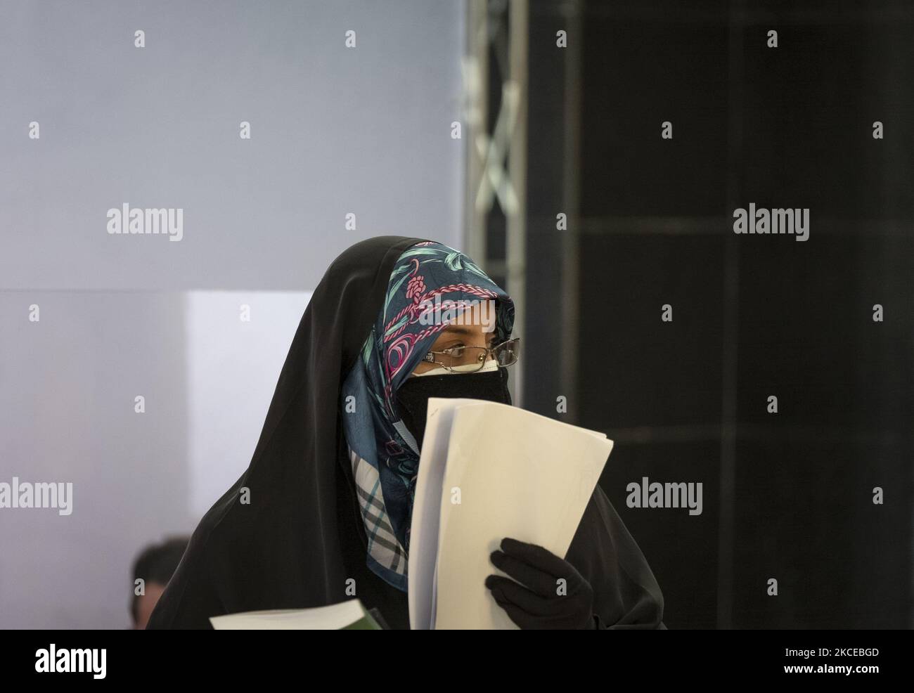 Niloufar Dabaghi, de 43 años, con una máscara protectora para la cara que llevaba sus documentos mientras asistía a la sede de las elecciones en el edificio del Ministerio del Interior iraní para inscribirse como candidata a las elecciones presidenciales del 18 de junio en Irán, en el centro de Teherán, el 11 de mayo de 2021. (Foto de Morteza Nikoubazl/NurPhoto) Foto de stock