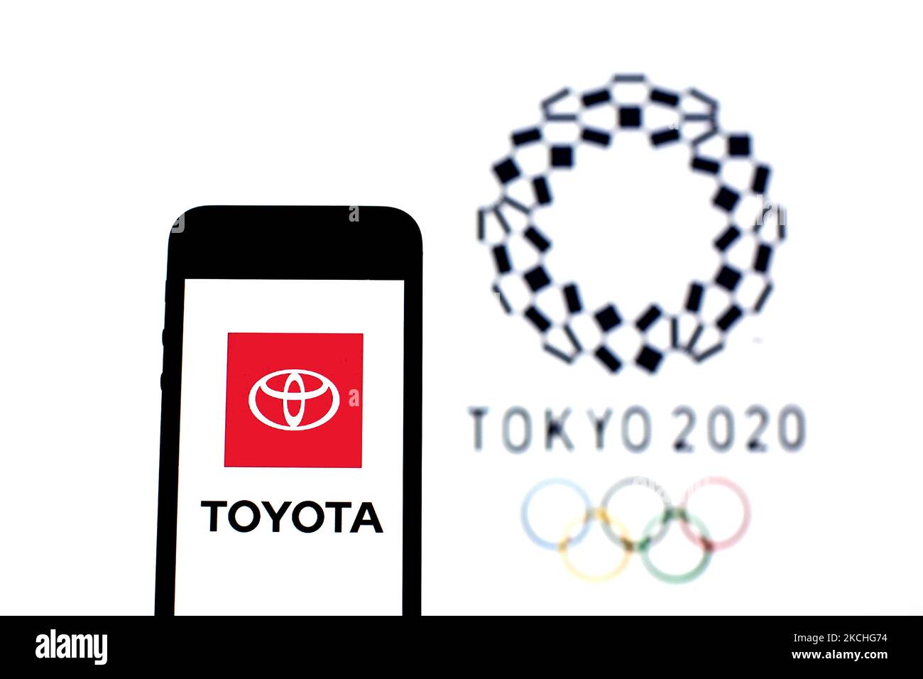En esta ilustración de la foto aparece un logotipo de Toyota Motor Corporation en un smartphone con un logotipo de los Juegos Olímpicos de Tokio 2020 en el fondo. (Foto de DAX Images/NurPhoto) Foto de stock